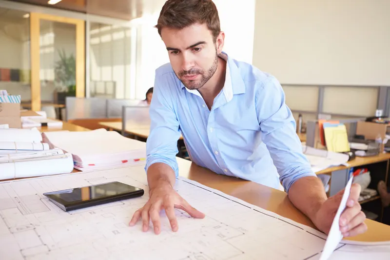 An architect examining a set of construction plans